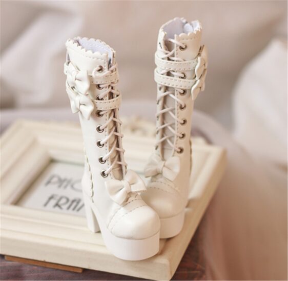 a pair of white boots with bows on a white frame